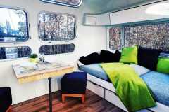 Airstream Living Tiny Home Kaufen Verkauf Wohnwagen Sitzecke Couch Tisch Fenster 1